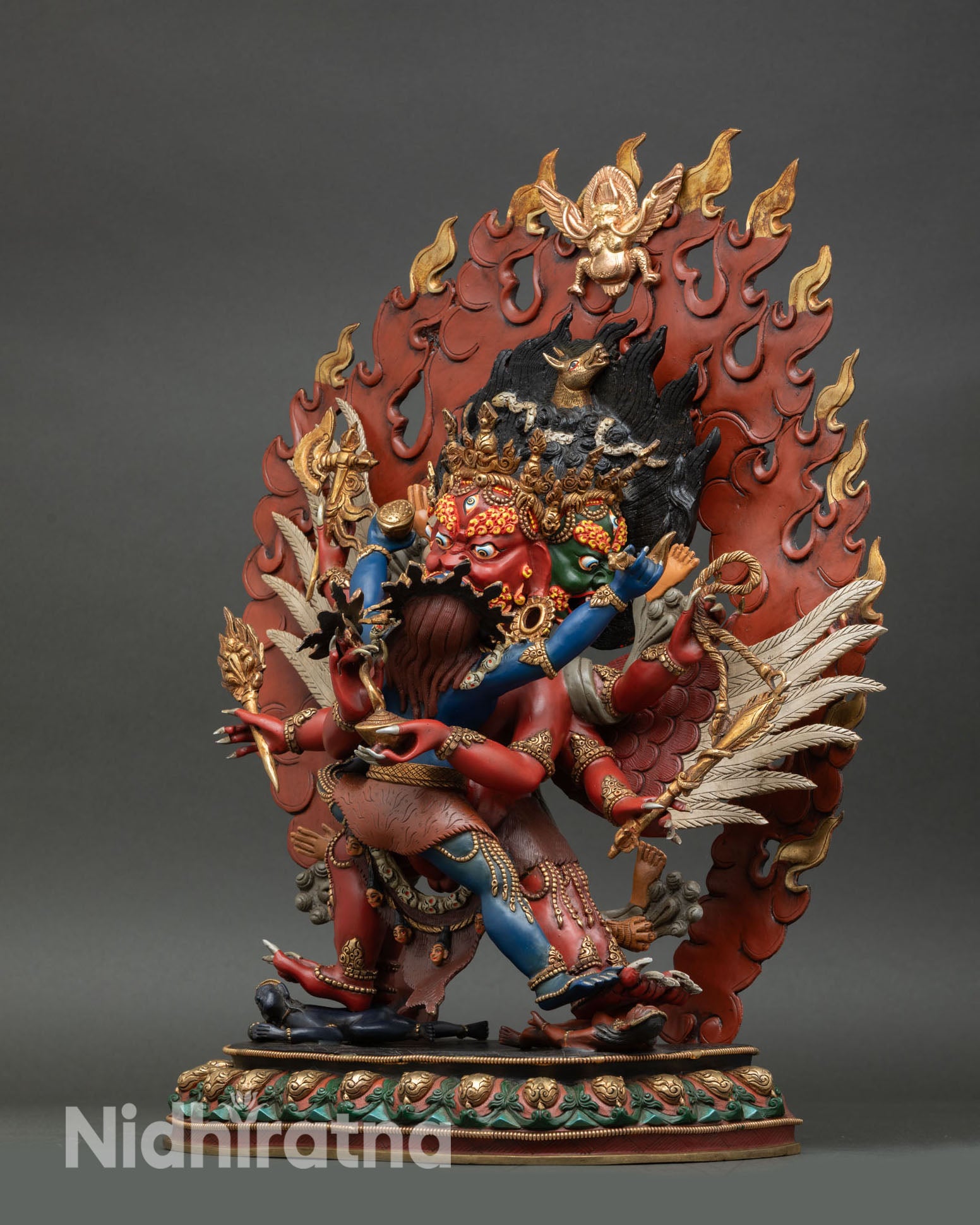 left side view of hayagriva sculpture with detailed wings, lotus seat and dynamic stance