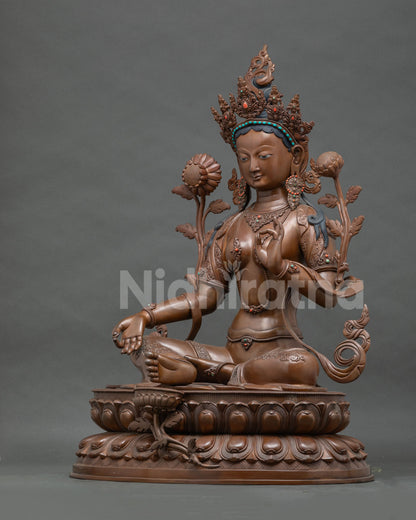 Left side view of large oxidized copper Green Tara statue on double lotus pedestal