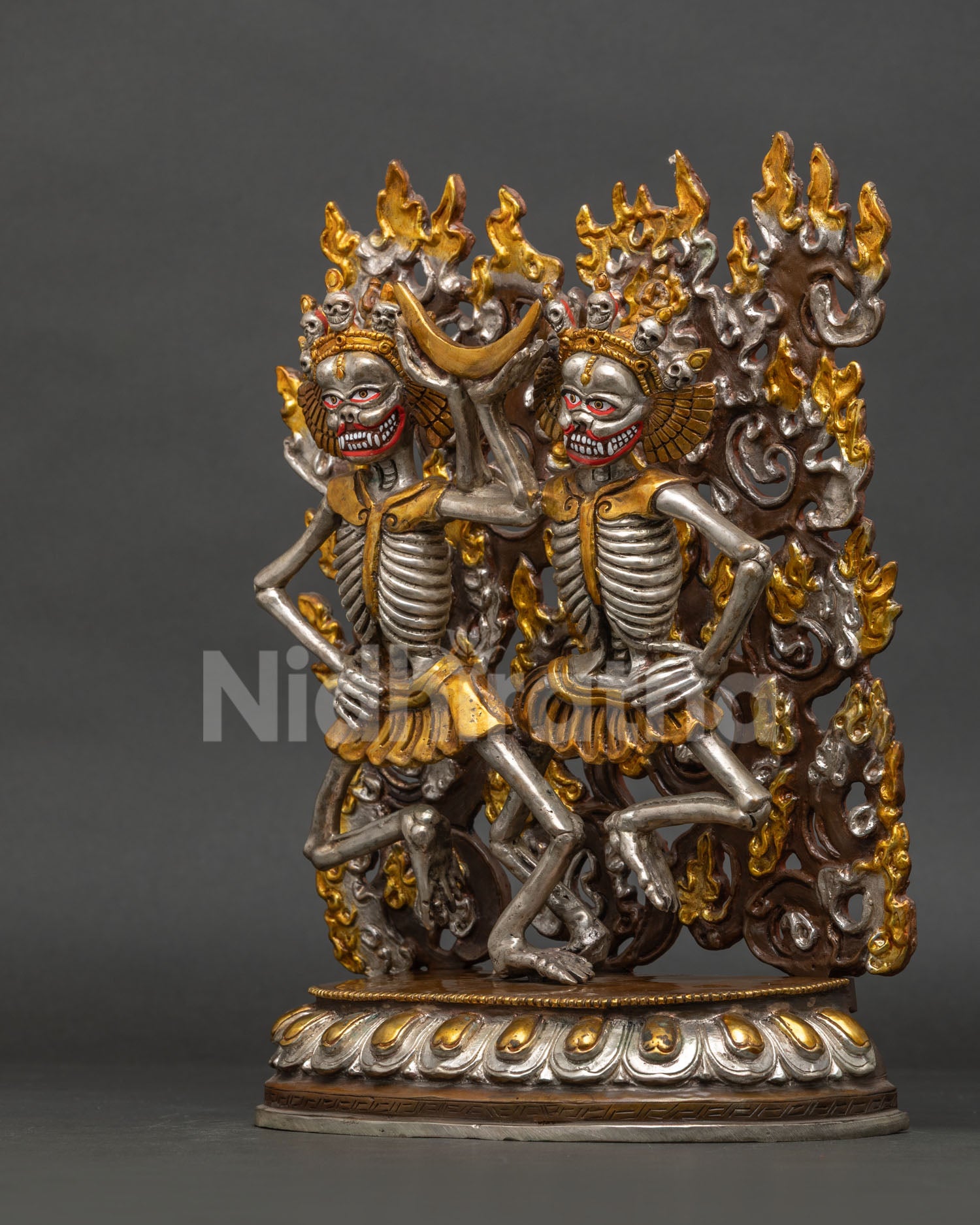 Left side view of Nepalese Citipati skeleton statue with gold and silver details
