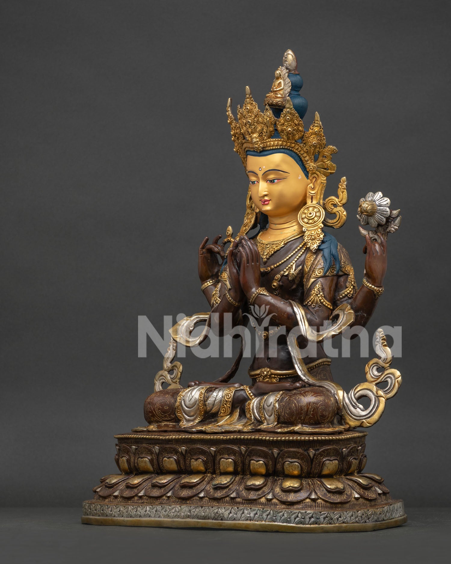Left side view of oxidized copper Avalokiteshvara statue highlighting detailed silver plating and lotus base.