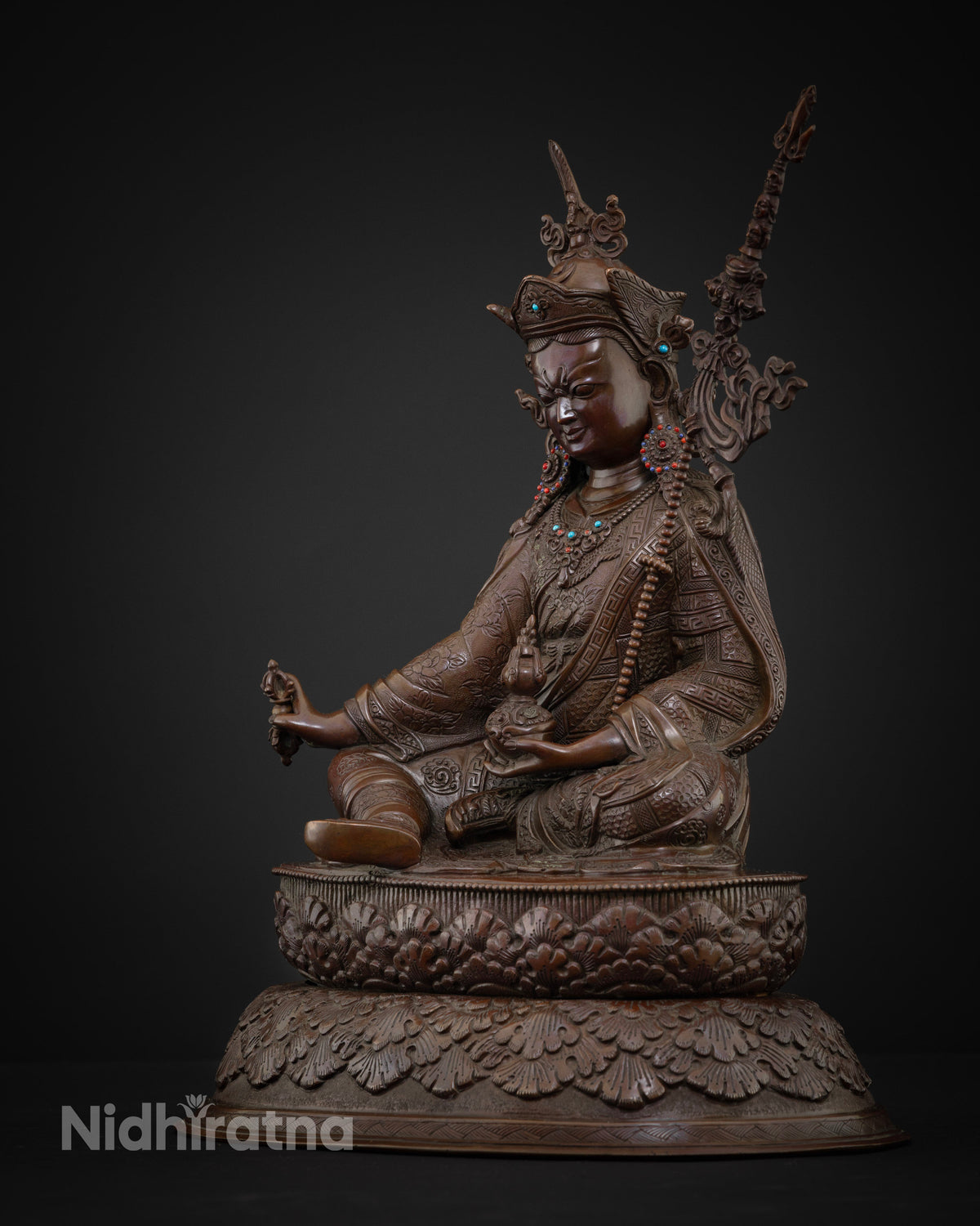 Left side view of oxidized copper Guru Rinpoche statue on lotus base, handcrafted in Nepal