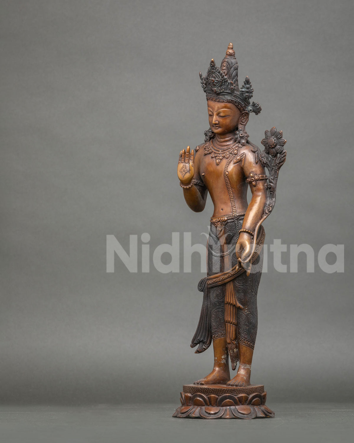 Left side view of oxidized copper Lokeshvara statue showing antique patina and lotus stem detail