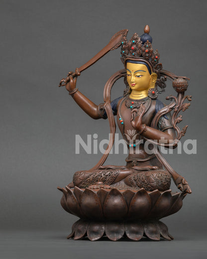 left side view of oxidized manjushri statue with sacred lotus base