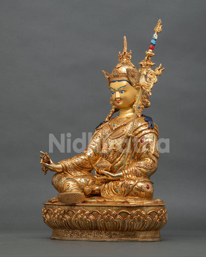 Left side view of Padmasambhava statue with vajra, kapala and gold fire-gilding