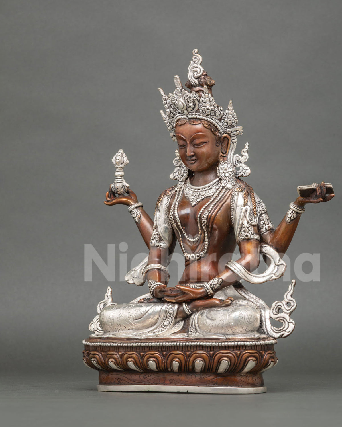 Left side view of Prajnaparamita statue holding a sutra, oxidized copper with silver details