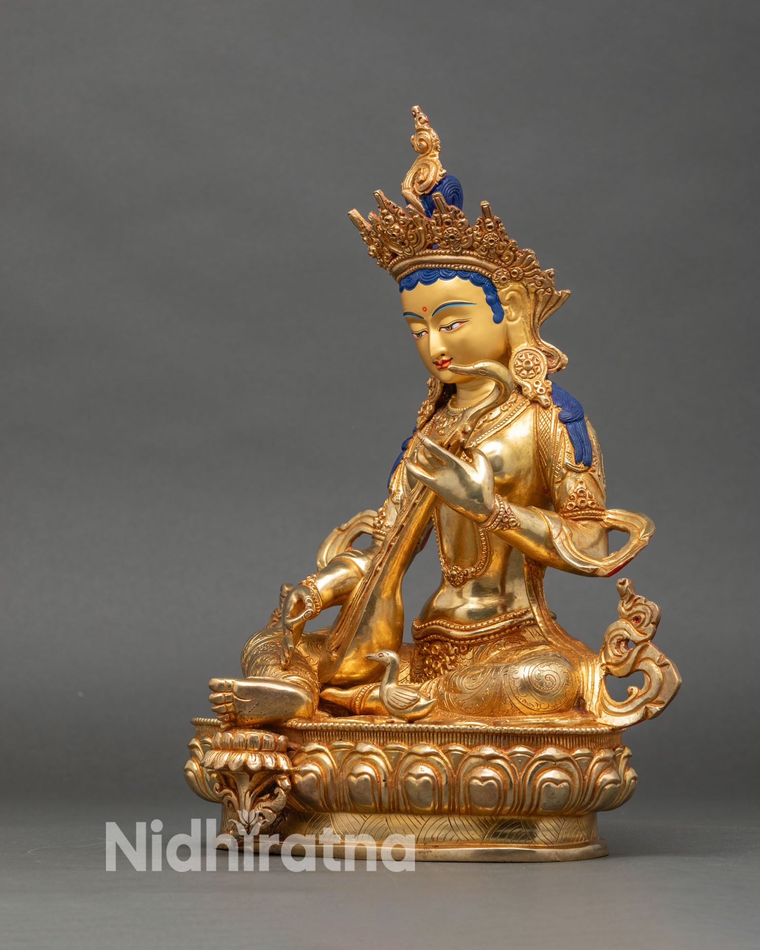 Left side view of Saraswati statue seated on lotus, traditional Hindu goddess art