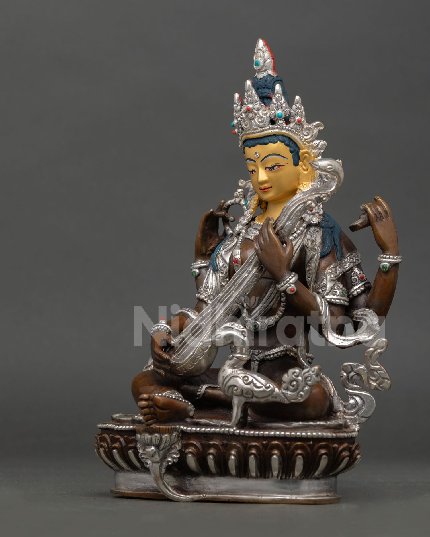 Left side view of Saraswati statue with veena, traditional Himalayan metalwork