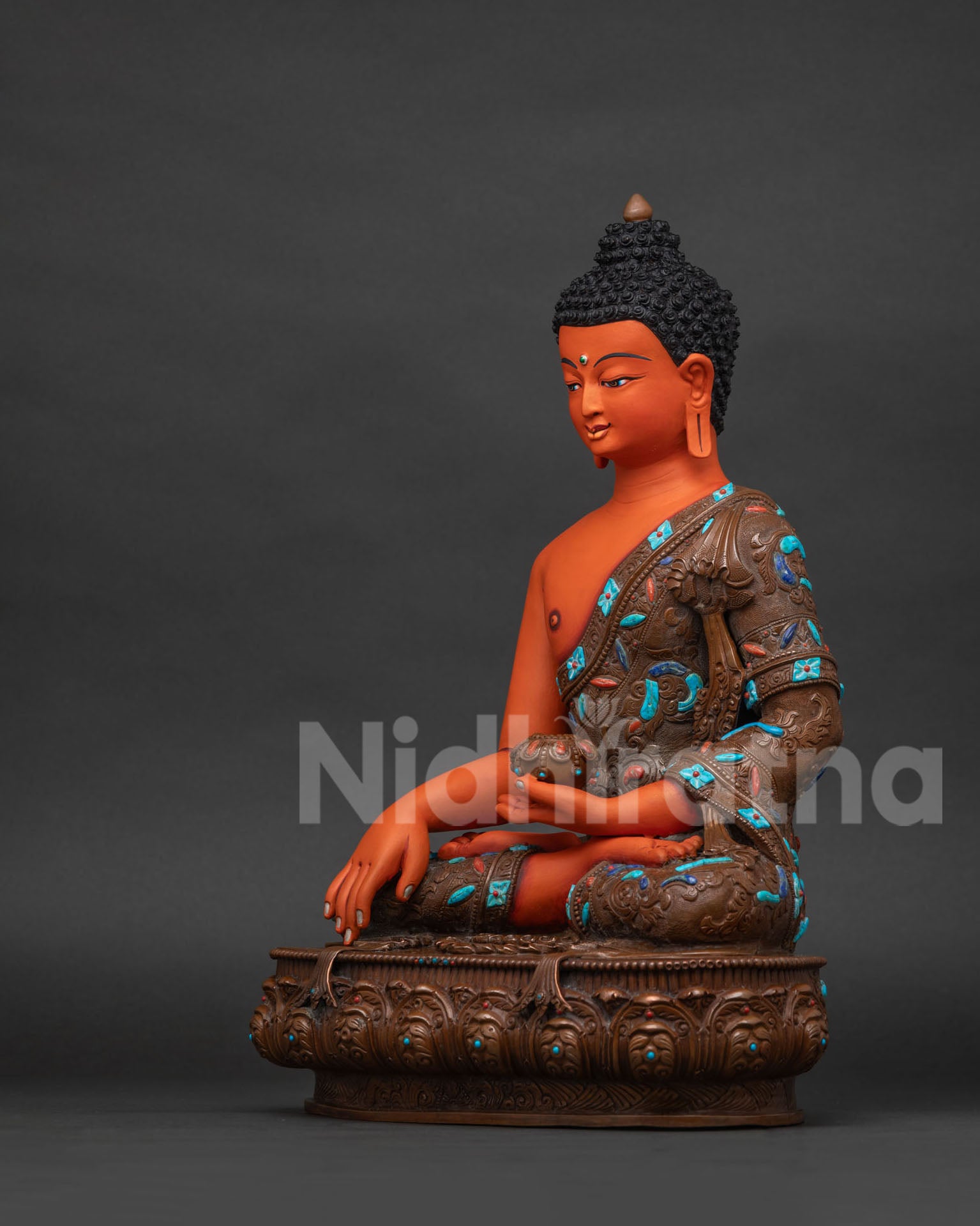 Left side view of Shakyamuni Buddha statue holding alms bowl on carved lotus pedestal