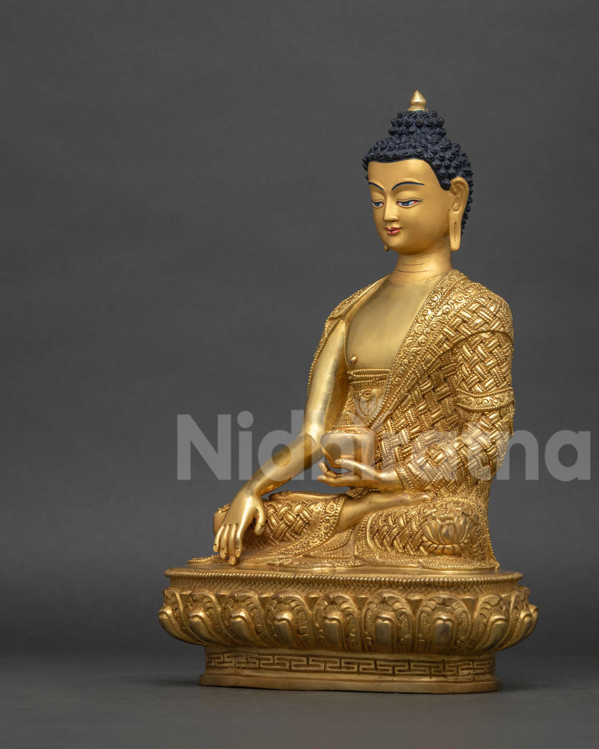 Left side view of Shakyamuni Buddha statue holding begging bowl, gold fire-gilded copper