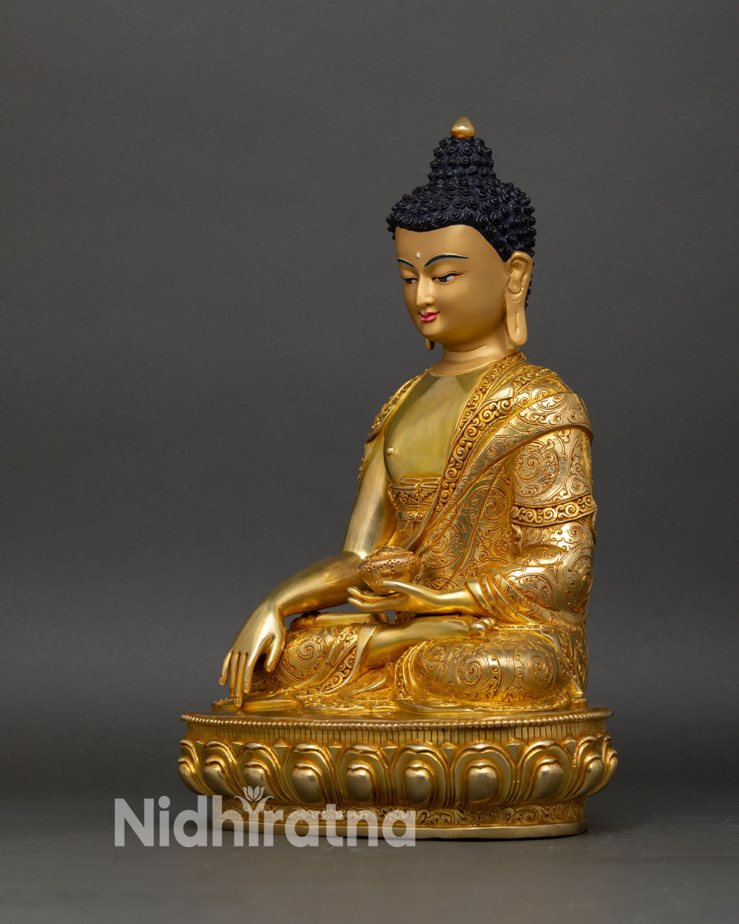 Left side view of Shakyamuni Buddha statue showing alms bowl and floral robe details