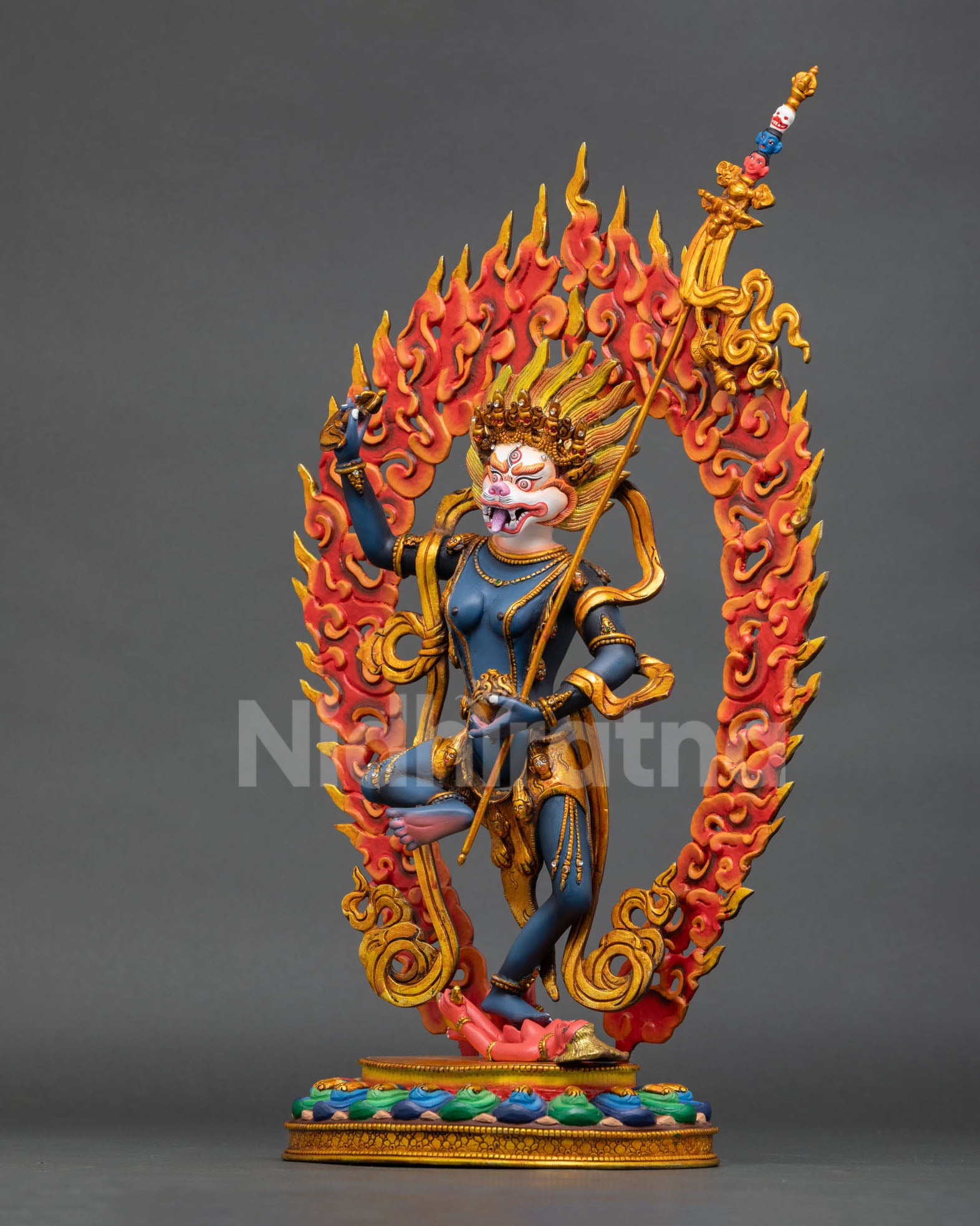 left side view of simhamukha buddhist statue with flowing robes and sacred details