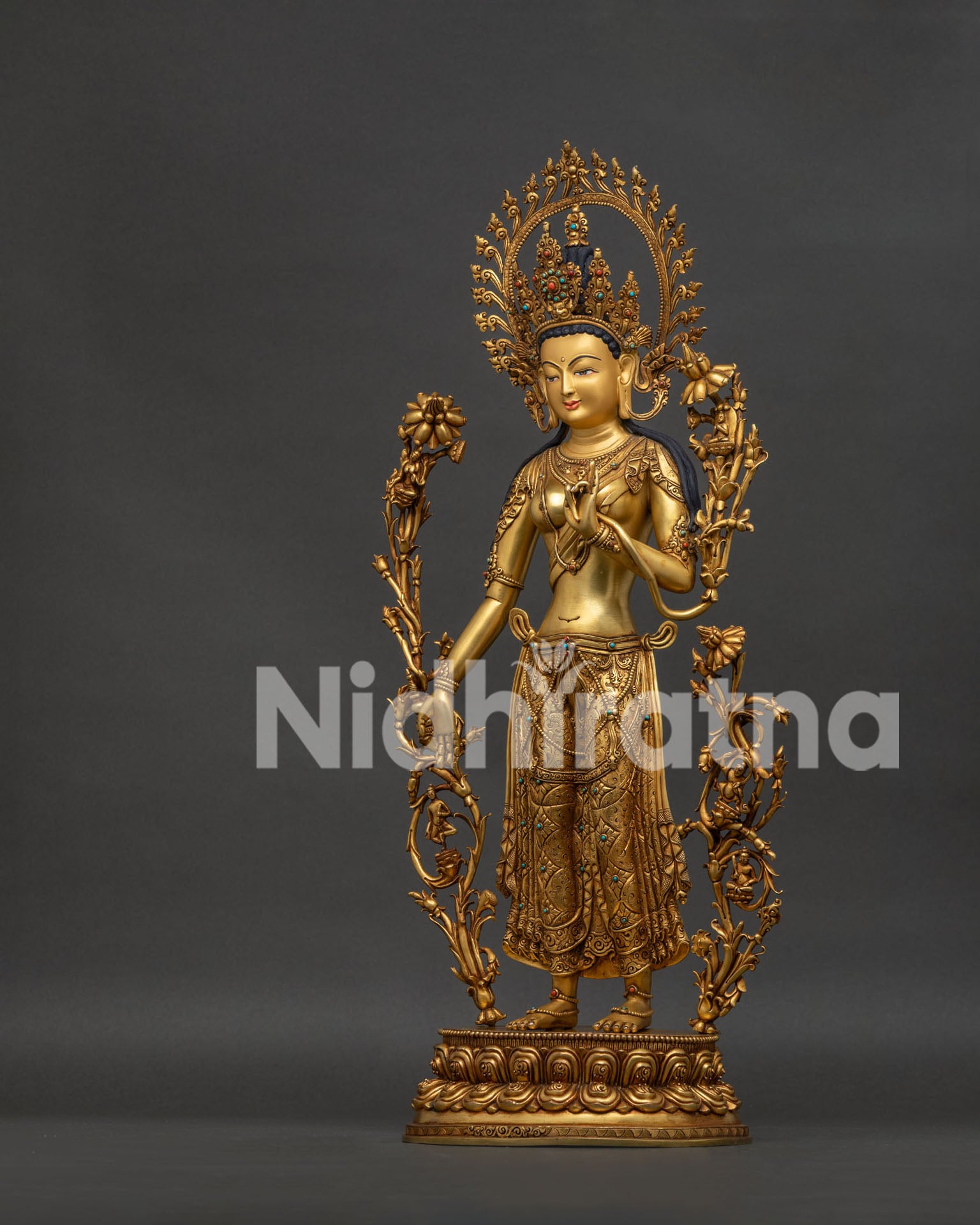 left side view of standing green tara showing detailed repoussé work and gemstone ornaments