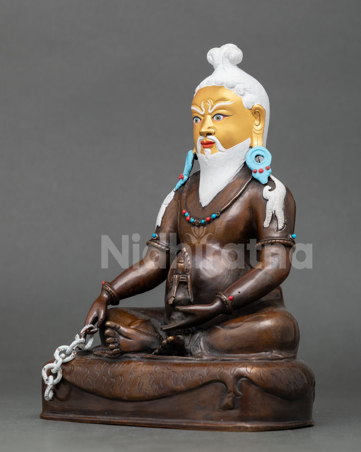 Left-side view of Thangtong Gyalpo Buddhist statue seated on striped deer skin