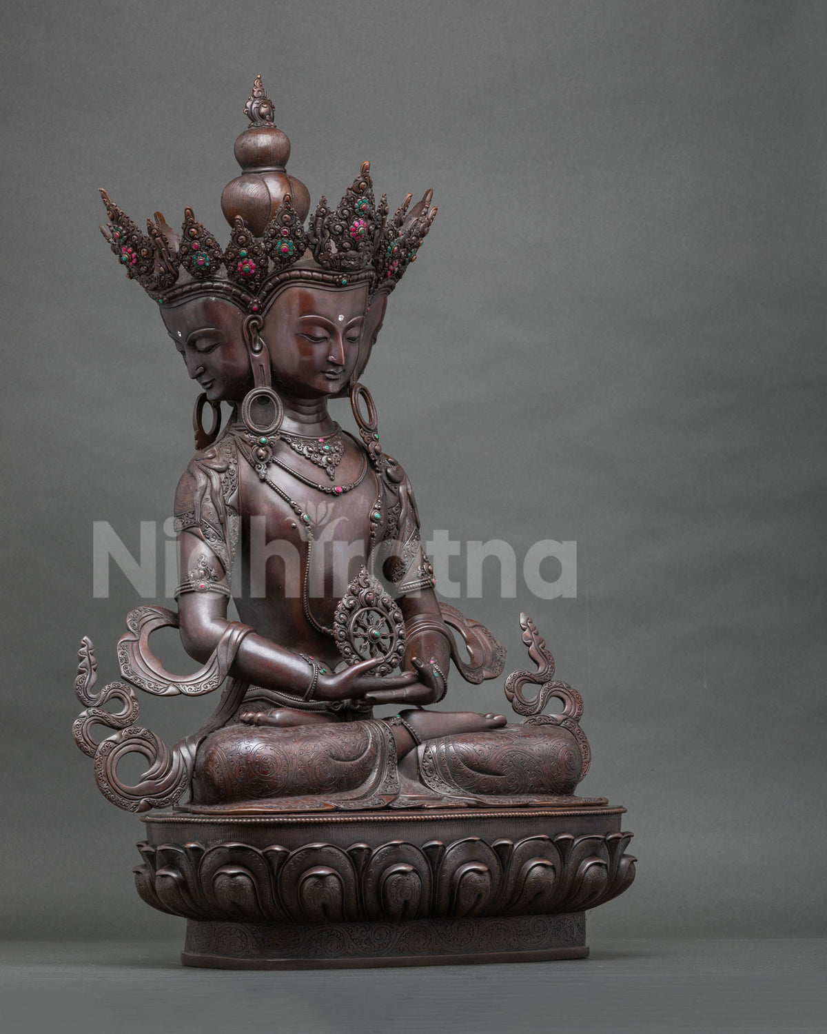 Left side view of the seated Sarvavid Vairocana copper statue on a double-layered lotus pedestal
