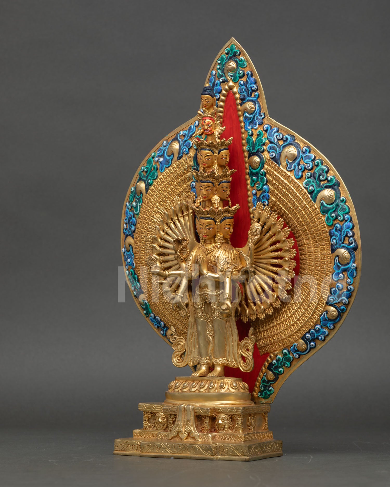 left side view of thousand armed avalokiteshvara statue with lotus base and ornaments