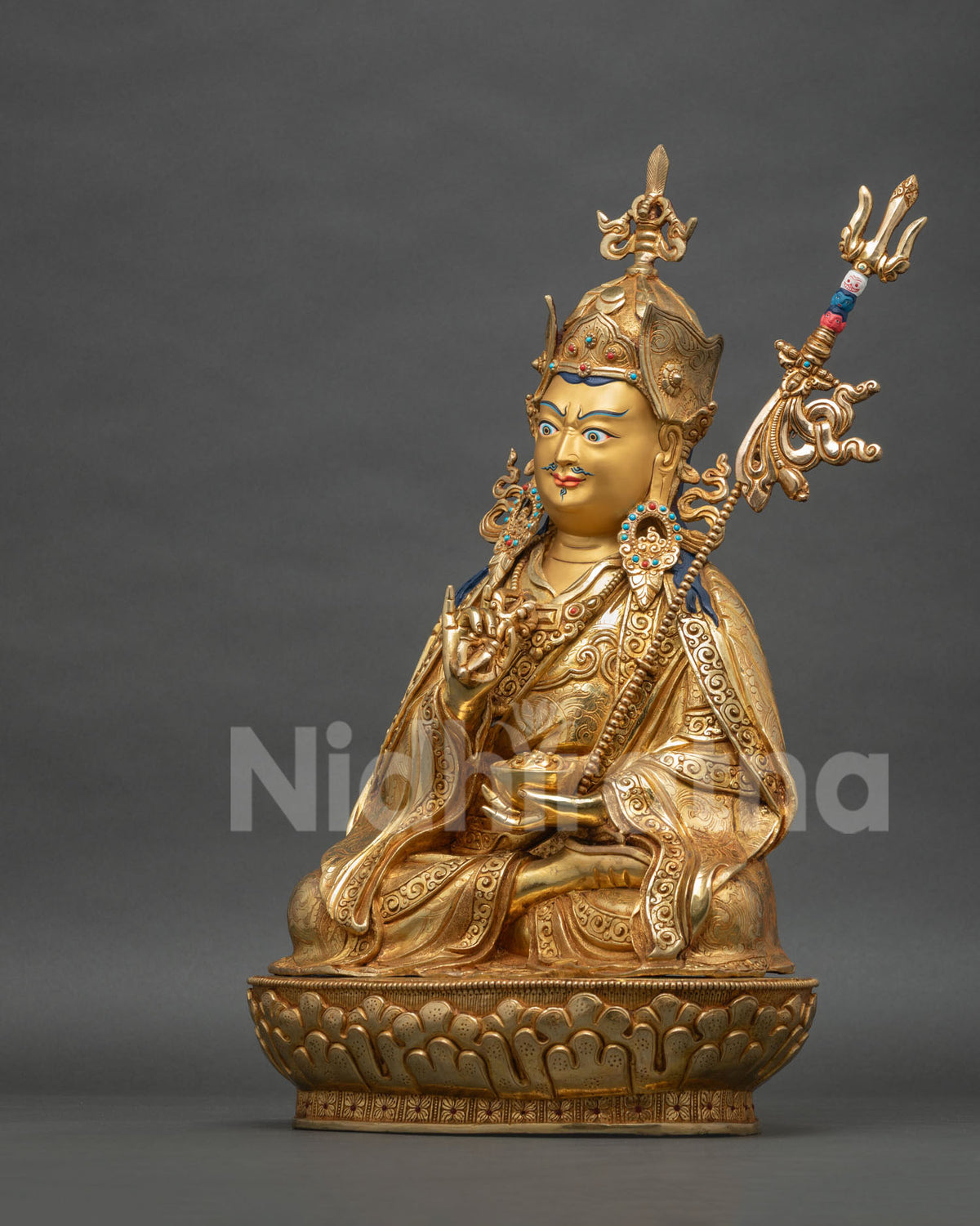 Left side view of Tsokye Dorje statue with khatvanga staff, trident and gold-gilded lotus pedestal