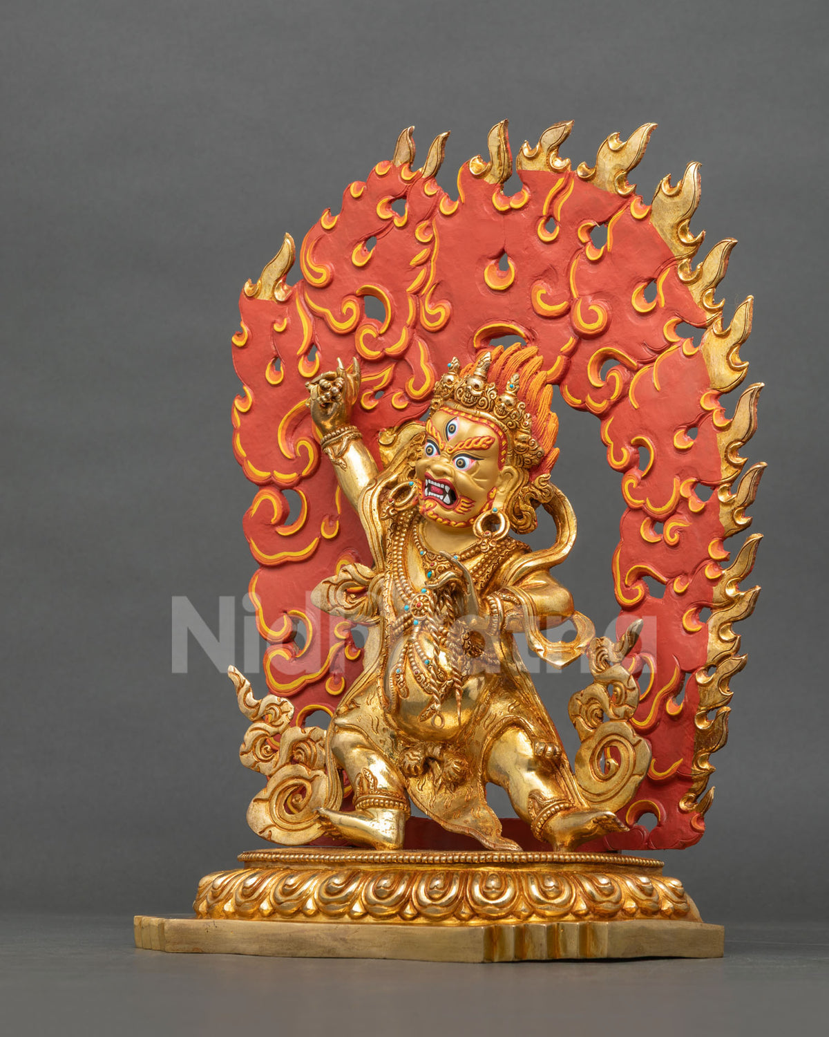 Left side view of Vajrapani statue in wrathful stance with flaming halo, gold-gilded copper