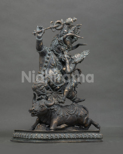 Left side view of Yamantaka Vajrabhairava bronze statue with raised khatvanga staff and buffalo base