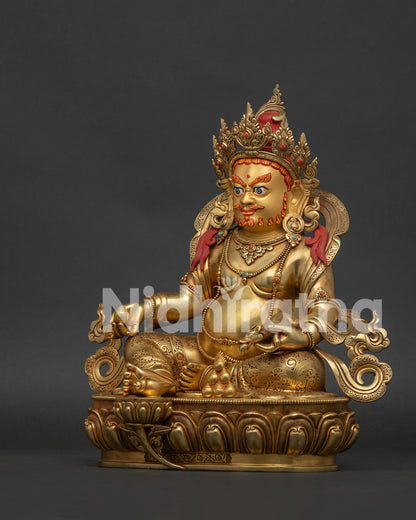 left side view of Yellow Dzambhala statue holding a jewel-spitting mongoose on lotus pedestal