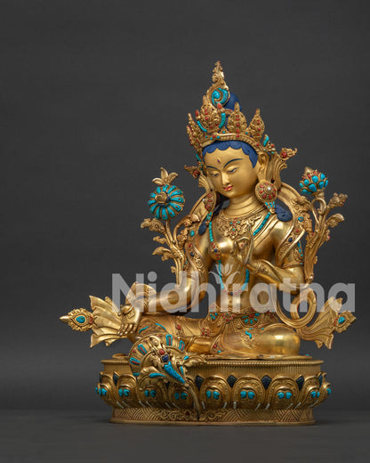 Left view of handcrafted Green Tara statue displaying vitarka mudra and blooming lotus.