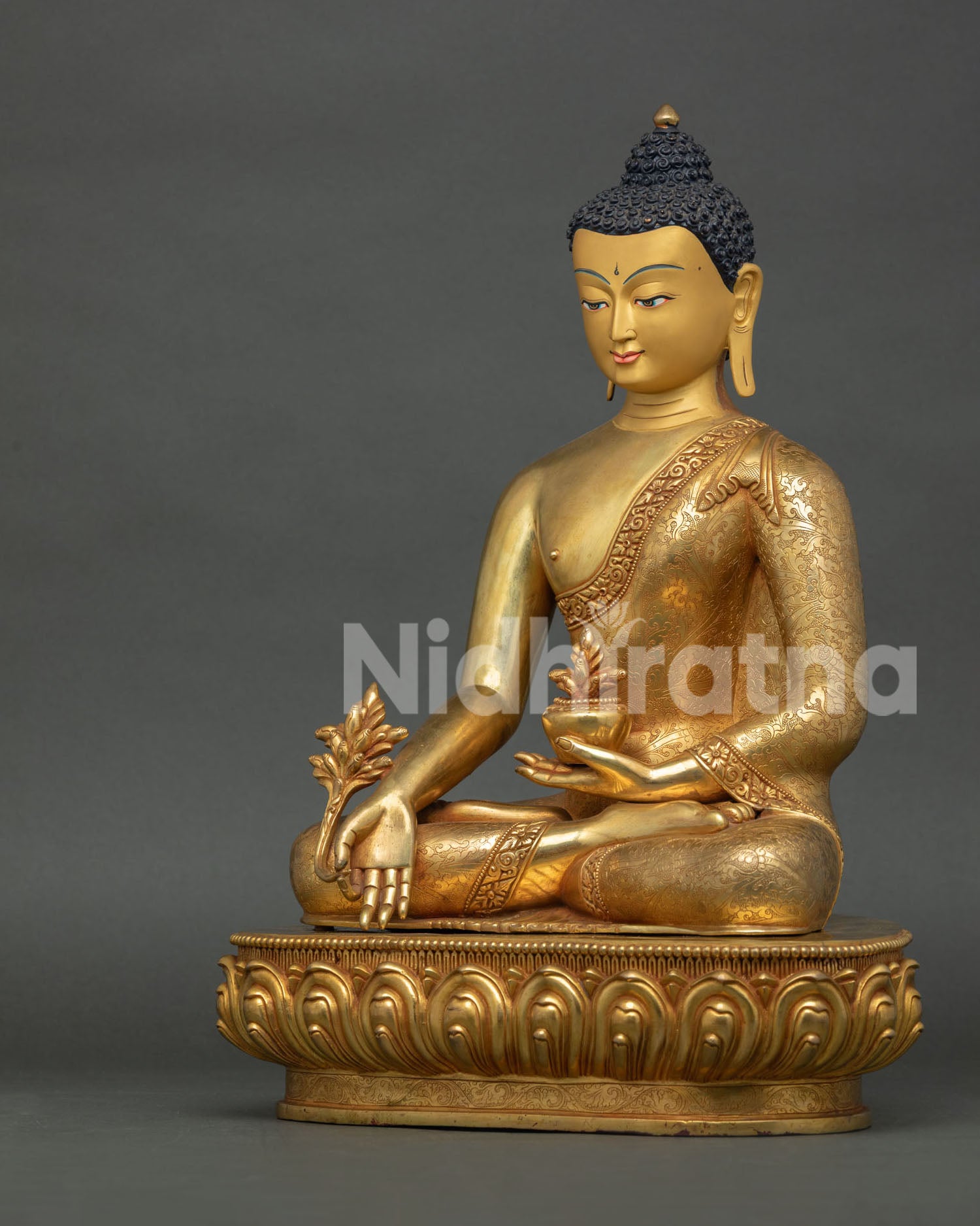 left view of handcrafted medicine buddha statue in fire-gilded copper from nepal