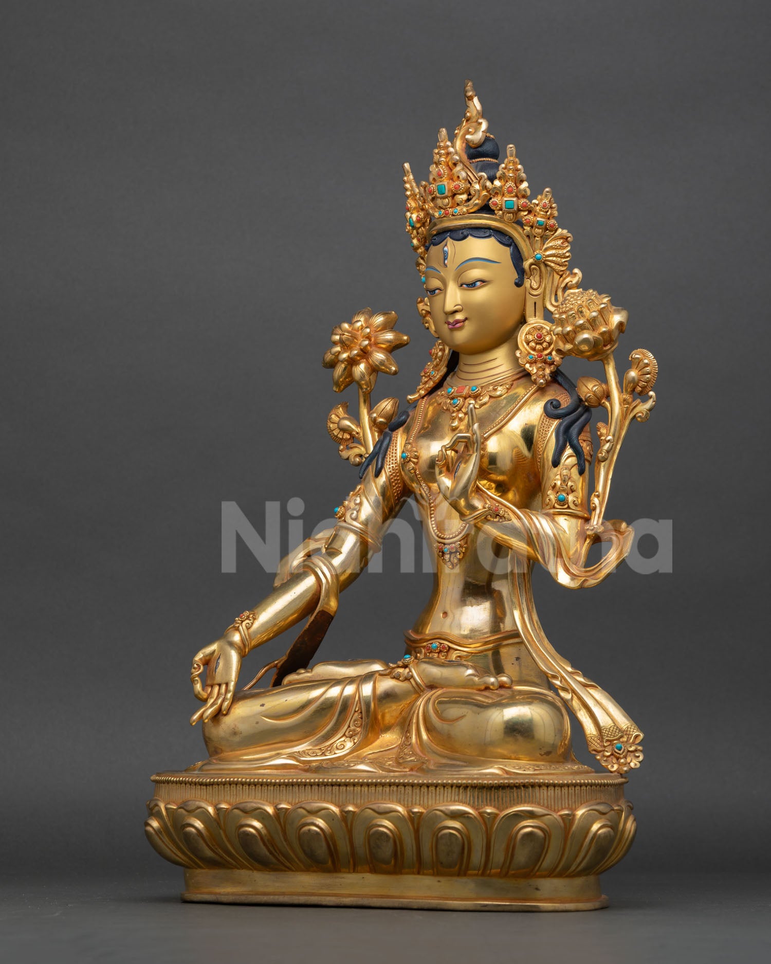 left view of white tara buddhist statue with intricate repoussé artisan craftsmanship