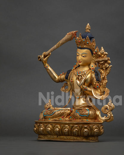 Left side view of handcrafted Manjushri copper statue with gold gilded details