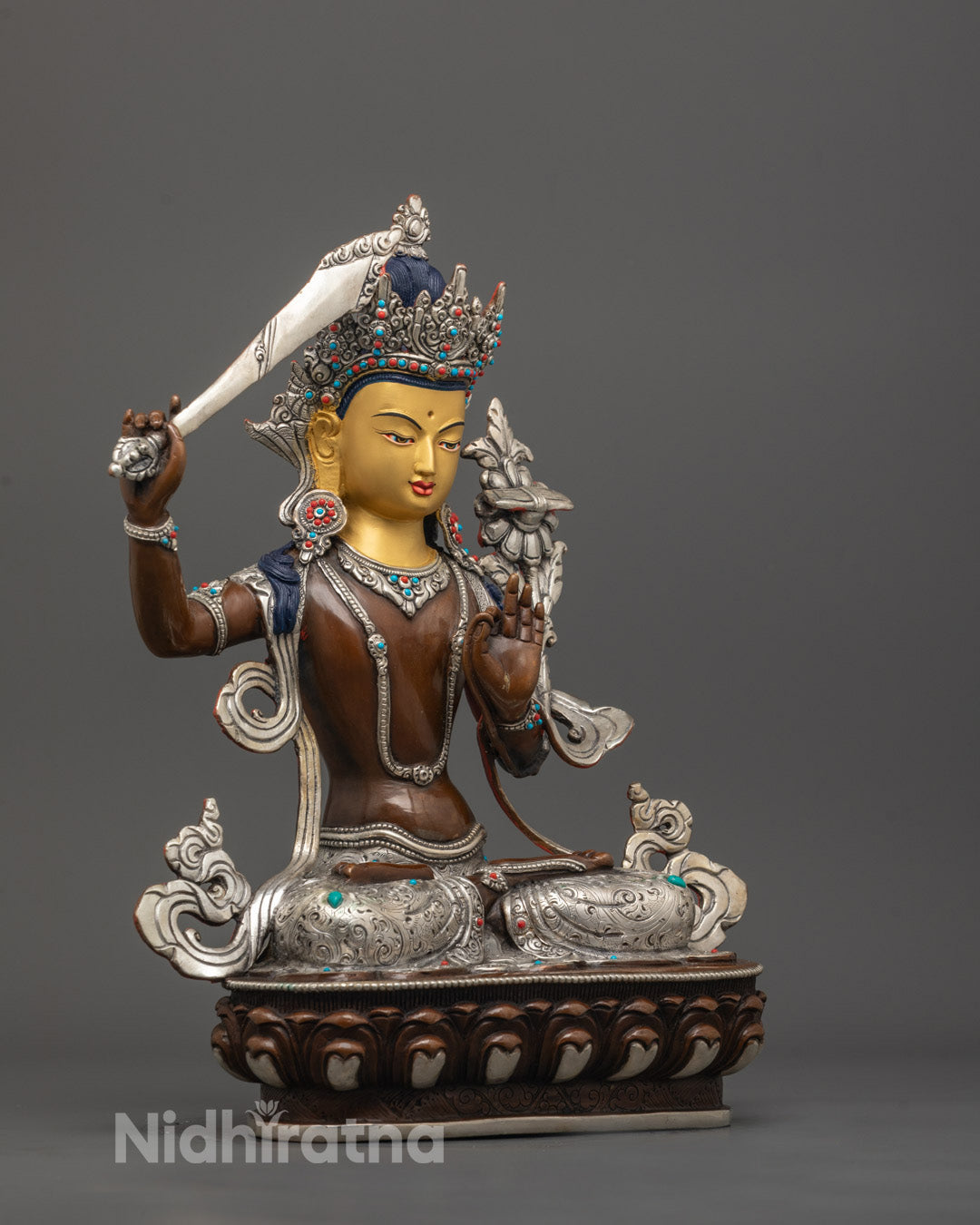 left side view of Manjushri Statue showing oxidized copper body and silver-plated robe