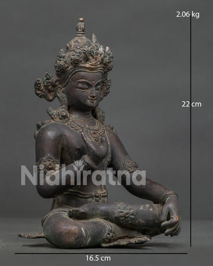Lokeshvara statue seated in serene meditation posture with ornate crown and jewelry.