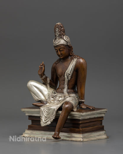Lokeshwor statue seated on pedestal with silk garment and silver crown.