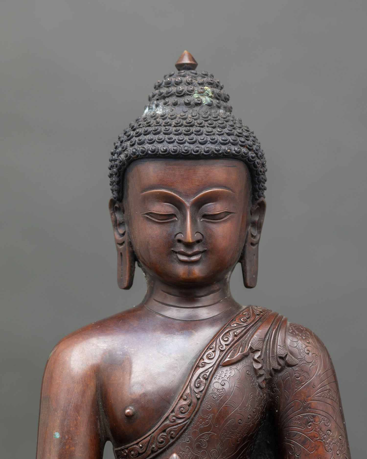 Close-up of Medicine Buddha hands holding healing nectar bowl and blessing mudra