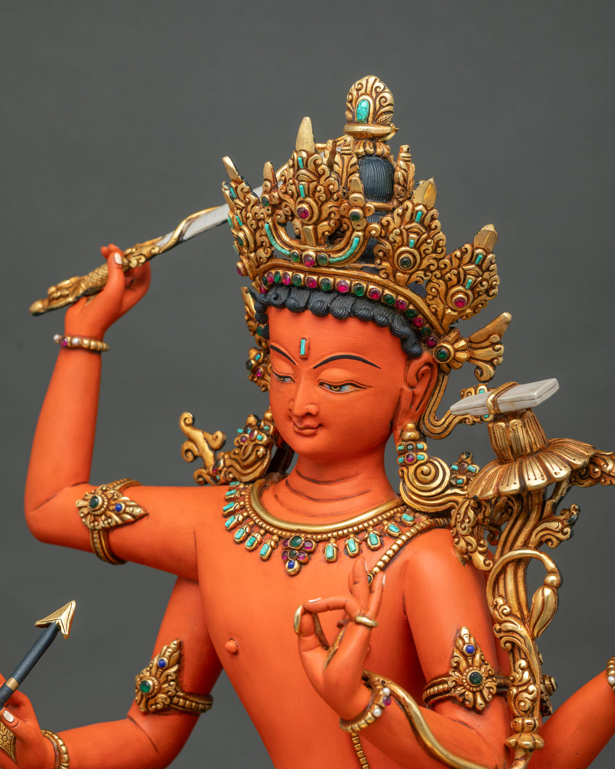 Maha Manjushri statue close-up showing gold-gilded crown, serene face and utpala flower with sutra