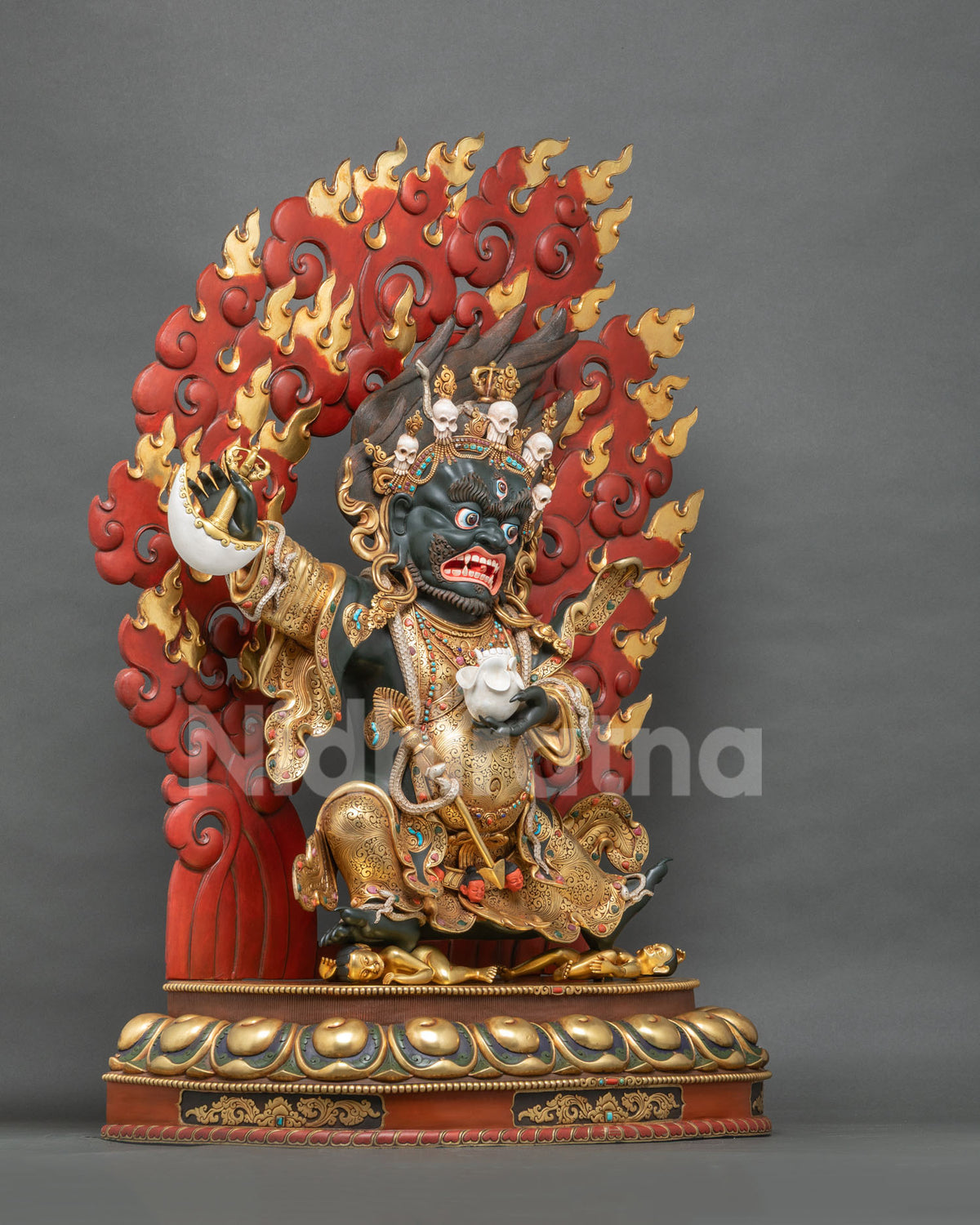 Mahakala Bernagchen statue three-quarter view with crimson flame halo and gilded lotus pedestal