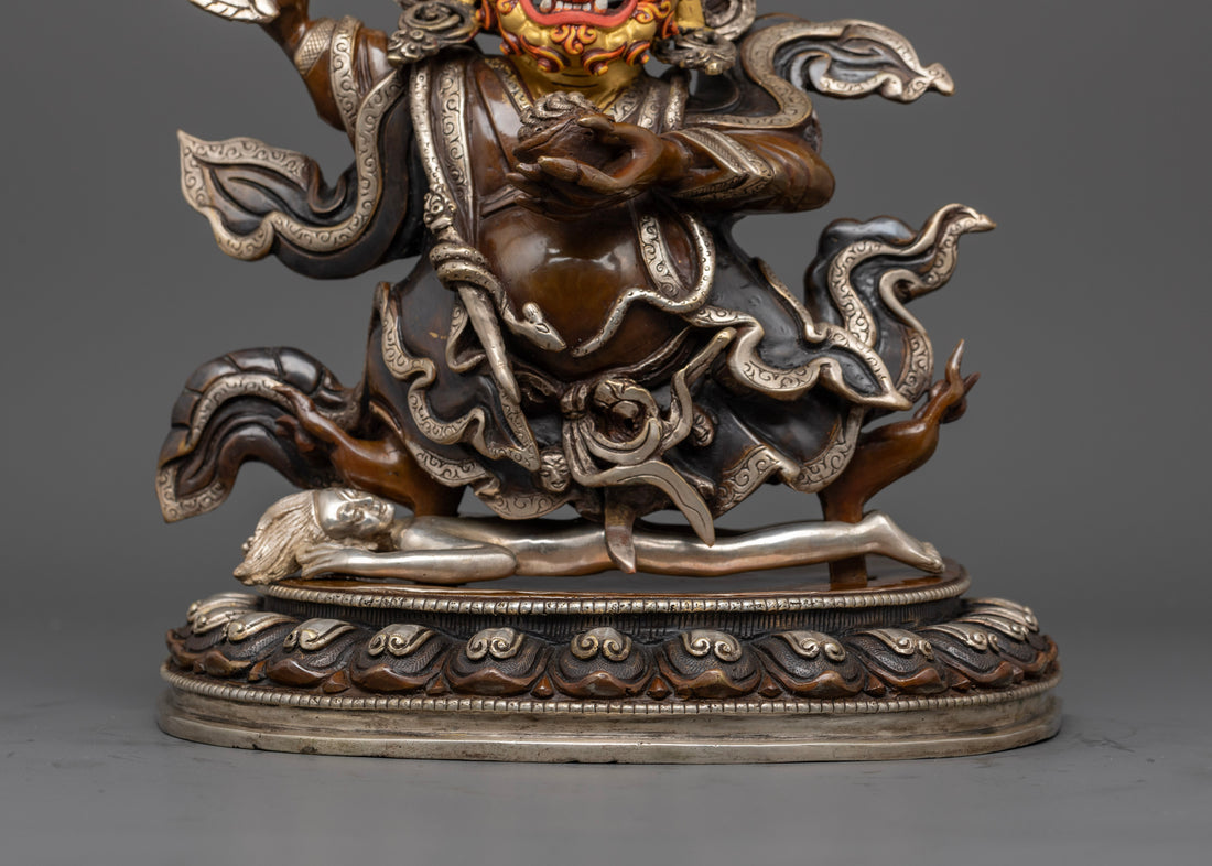 flowing robes of mahakala bernagchen statue with silver accents on brown oxidized copper base