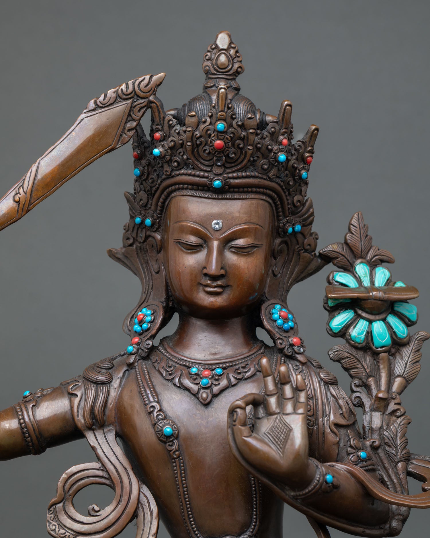 Close-up of Manjushree Bodhisattva Statue holding flaming sword of wisdom, traditional lost wax cast copper sculpture from Nepal