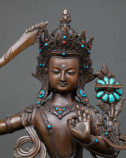 Close-up of Manjushree Bodhisattva Statue holding flaming sword of wisdom, traditional lost wax cast copper sculpture from Nepal