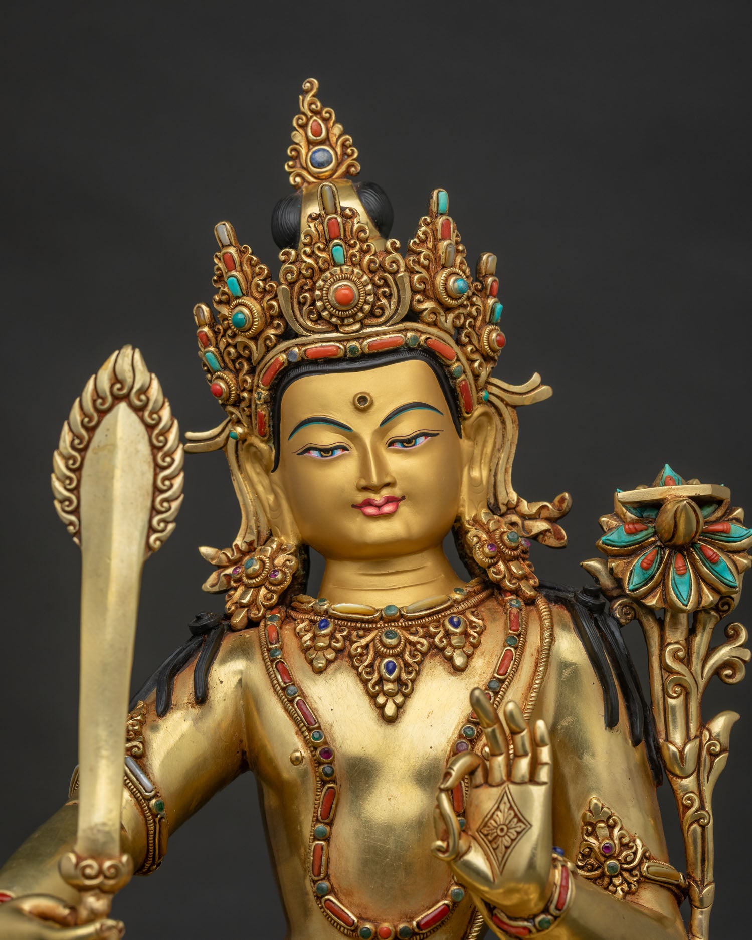 Manjushri statue gold-painted face close-up with five-jeweled crown and turquoise detailing