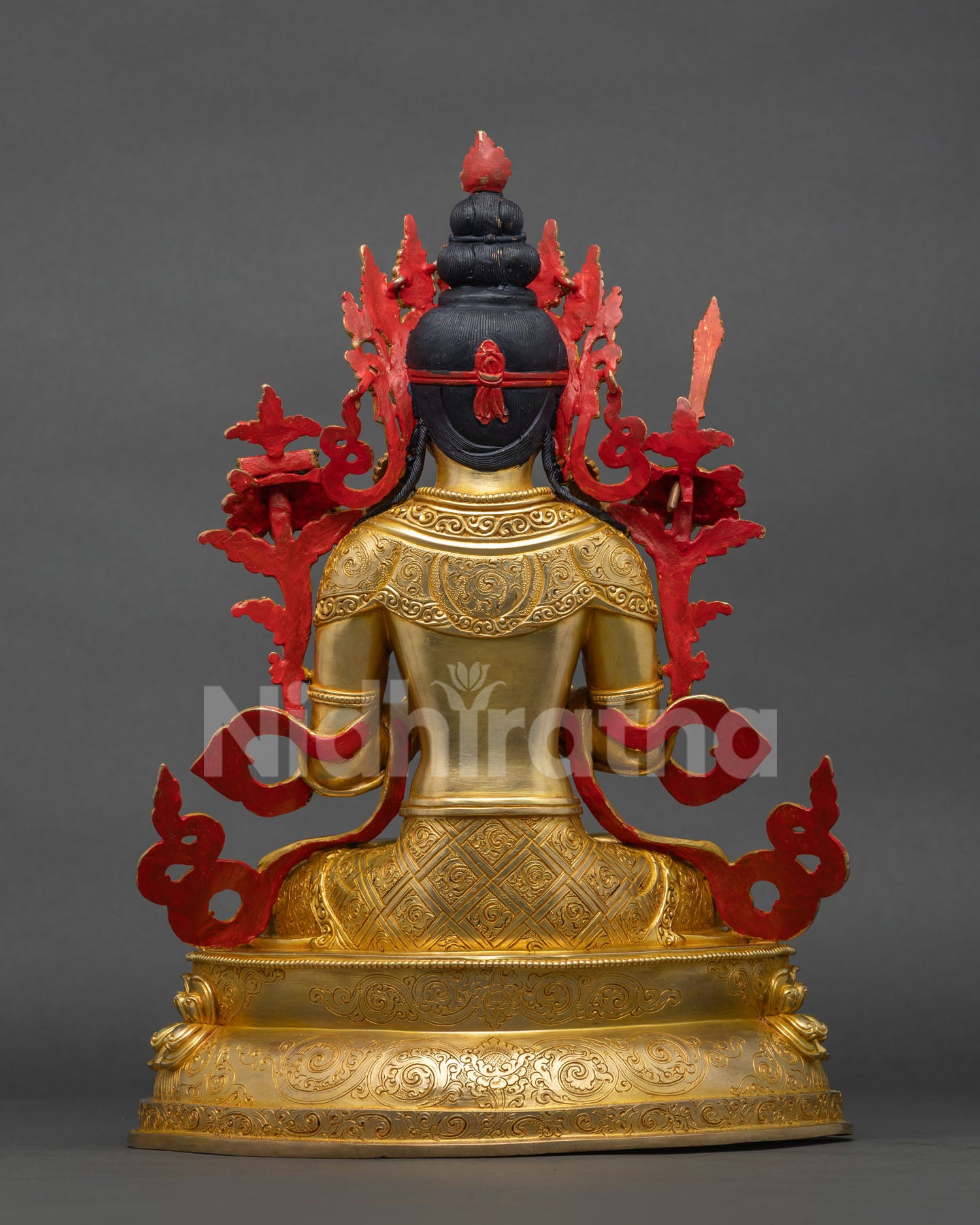 Back view of Manjushri statue showing flowing hair and gold-gilded robe detail