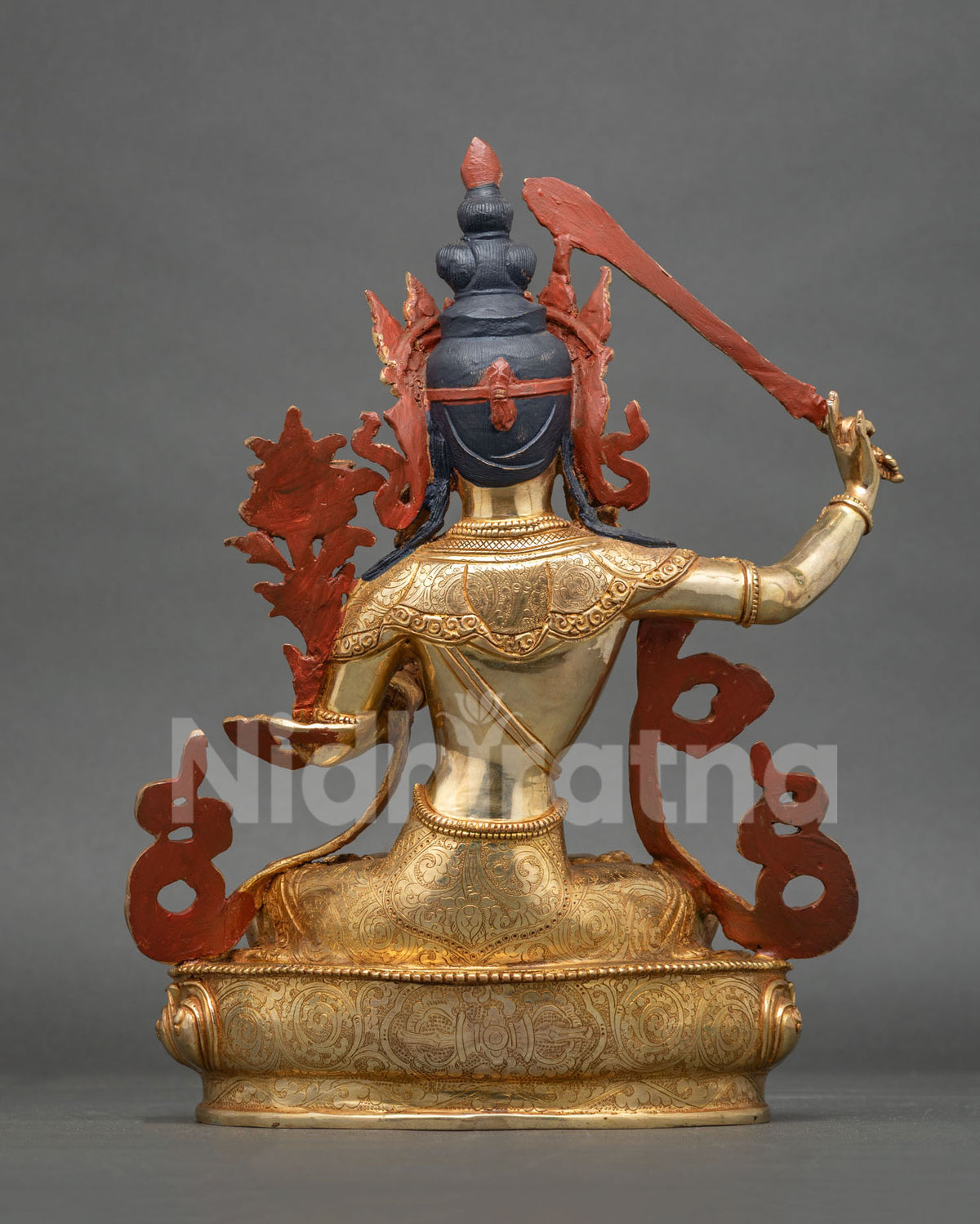Manjushri Statue back view intricate copper carvings floral silk garment.