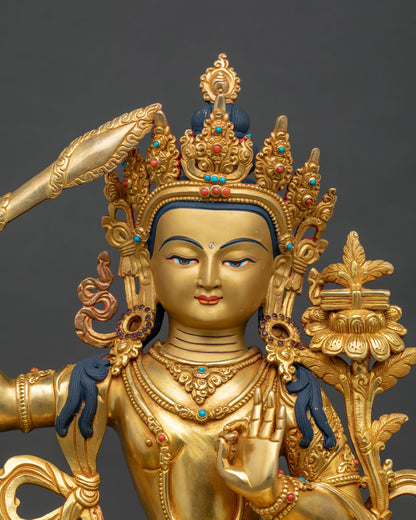 Manjushri Statue close up 24K gold painted face semi precious stones.