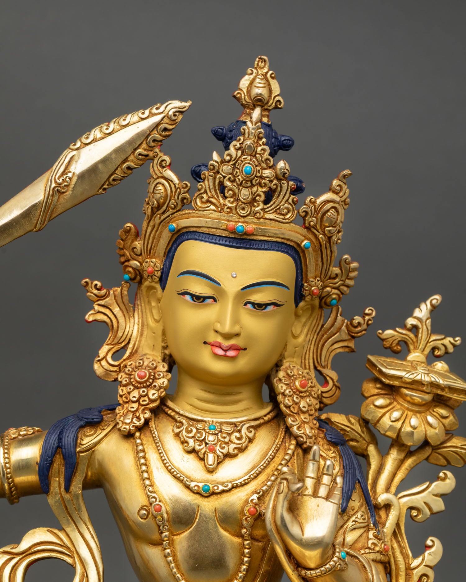 manjushri statue close up gold painted face semi precious stones detail himalayan art newari craftsmanship