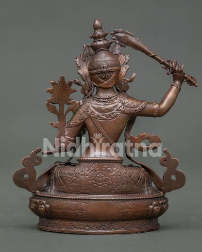 Manjushri statue displaying detailed copper artwork and himalayan buddhist design.