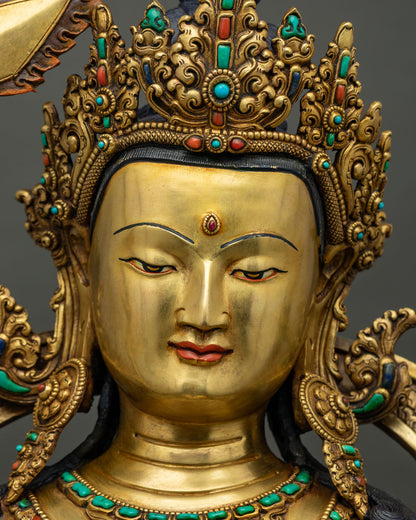 Manjushri statue face close up, gold-painted serene expression with ruby urna and jeweled crown, Nepal