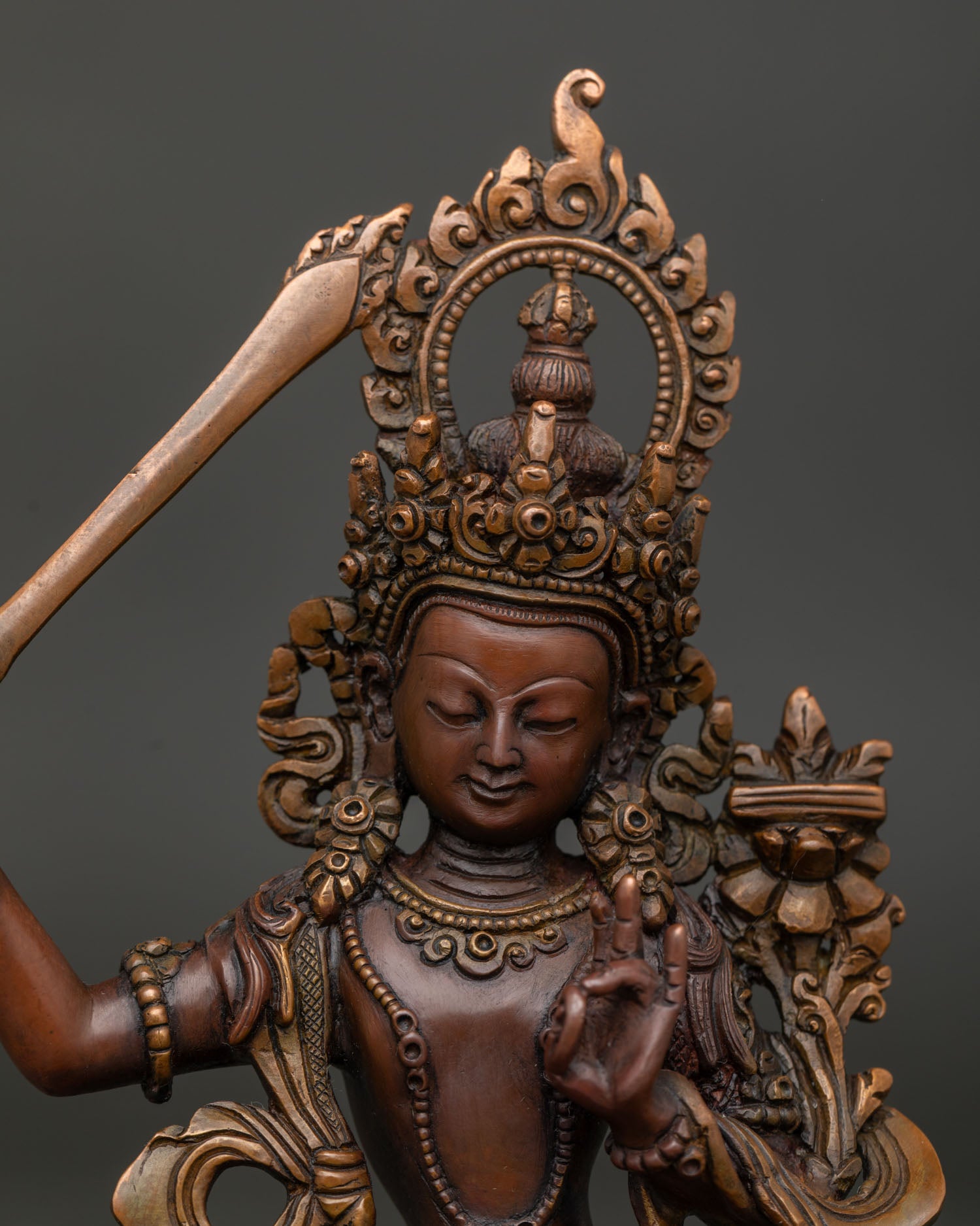 Manjushri Statue holding the flaming sword of wisdom and lotus.