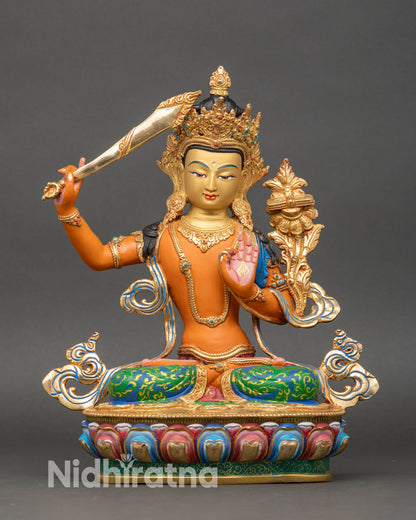 Manjushri Statue front view, orange shade with gold gilded ornaments and lotus base