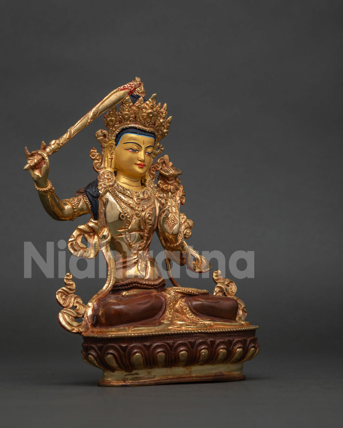 Manjushri statue holding the flaming sword of wisdom and sacred Prajnaparamita Sutra.