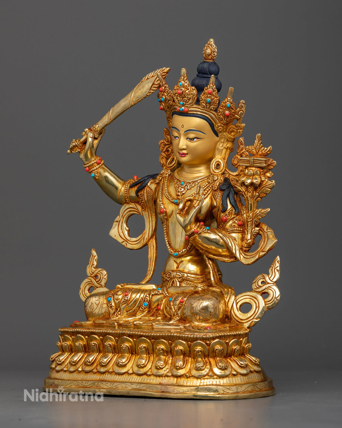Manjushri statue left view five jewel crown floral motif silk garment semi precious stones.