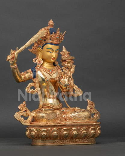 Manjushri statue raising flaming sword of wisdom and holding prajnaparamita sutra.