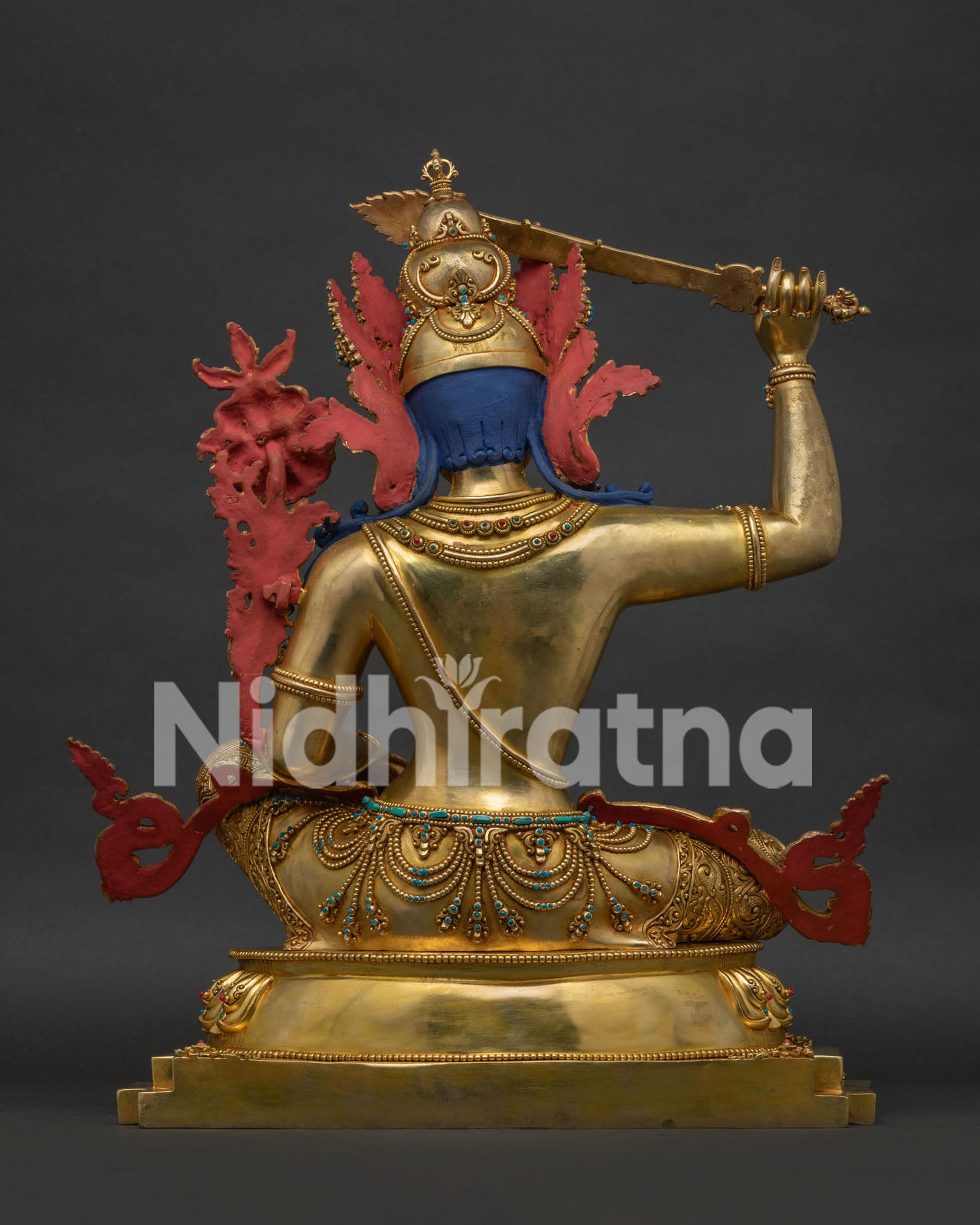 Manjushri statue rear angle, lotus base and guardian lion in gilded copper