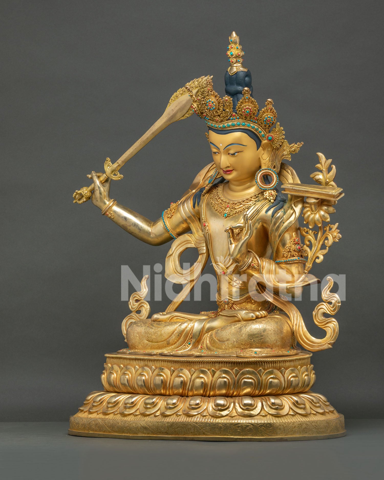 Manjushri statue side angle, flaming sword raised, copper gold fire-gilded